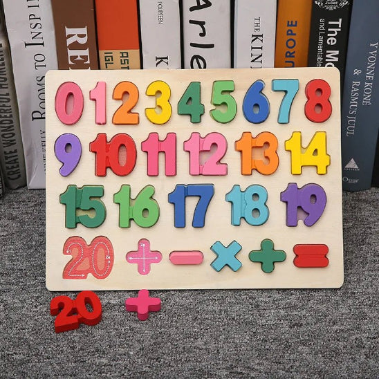 Le Puzzle 3D - Jouet bebe est un tableau en bois présentant des chiffres colorés de 0 à 20 et des symboles mathématiques, promouvant l'éveil et l'apprentissage. Le chiffre 20 et le signe plus sont affichés à l'avant, tandis que des livres sont visibles à l'arrière-plan.