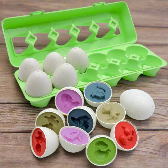 Le puzzle Oeufs - Jouet pour bébé est un carton en plastique vert contenant six oeufs mouchetés, dont certains s'ouvrent pour révéler des moules colorés en forme d'animaux à l'intérieur, présentés sur une surface en bois. Il s'agit d'un ensemble de jouets éducatifs Montessori.