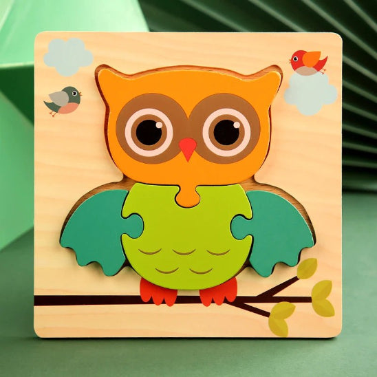 Les Puzzles - Jouets en bois représentent une chouette aux ailes vertes, à la tête orange et aux yeux bruns sur une branche, entourée de nuages, de deux oiseaux et de feuilles.