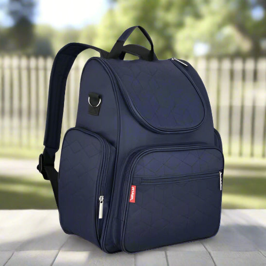 Le Sac à langer bébé - Élégant est un sac matelassé bleu marine avec deux poches avant zippées, une poche latérale, une poignée de transport supérieure, des bretelles réglables et une petite étiquette rouge, idéal pour les accessoires pour bébé.