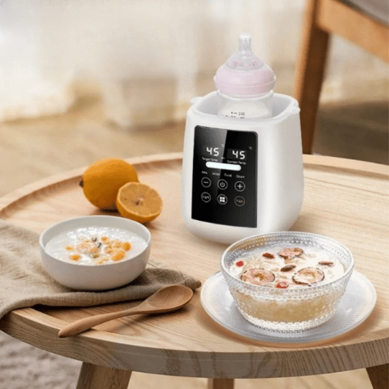 Le stérilisateur magique Chauffe-Biberons, idéal pour les tétées nocturnes et le réchauffement rapide du lait maternel, est posé sur une table ronde en bois, à côté d'un porridge, d'un bol en verre de céréales aux baies, d'une cuillère en bois et d'un citron en arrière-plan.