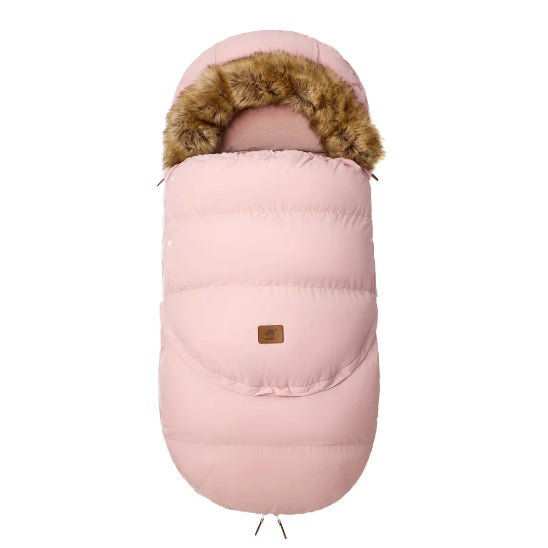 La Chancelière | 0-36 mois est une gigoteuse bébé rose avec capuche bordée de fourrure et patch logo marron, offrant une protection thermique pour le confort de bébé, présentée sur fond blanc.