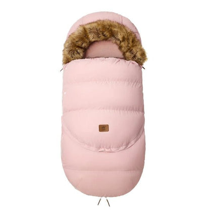 La Chancelière | 0-36 mois est une gigoteuse bébé rose avec capuche bordée de fourrure et patch logo marron, offrant une protection thermique pour le confort de bébé, présentée sur fond blanc.