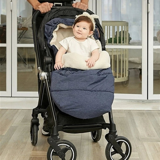 Un bébé dans une Chancelière Bébé - Care+ sourit, profitant du confort et de la protection thermique. Un adulte pousse la poussette à l'intérieur, avec de grandes fenêtres et un berceau visibles en arrière-plan.