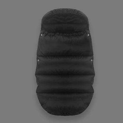 La chancelière Bébé, noire et rembourrée, est présentée sur fond gris. Conçue pour les poussettes et les sièges auto, elle offre des coutures horizontales, des boutons-pression latéraux et une protection thermique supérieure.