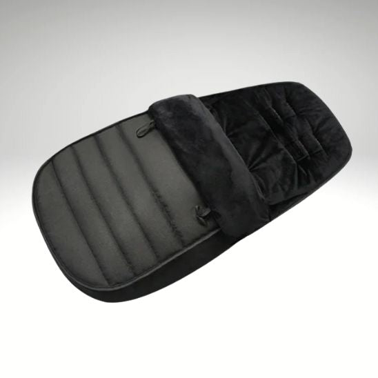 La chancelière bébé WarmCott™ est noire, rembourrée d'un intérieur en peluche et de coutures horizontales pour une excellente protection hivernale, conçue pour être utilisée dans une poussette ou un landau, présentée sur un fond neutre.