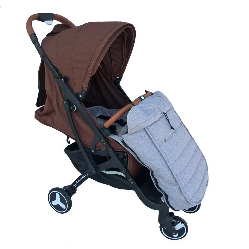 Poussette marron avec capote, châssis noir et poignées marron, équipée de la chancelière bébé WarmCott™ gris clair pour une protection hivernale optimale. Cette poussette à trois roues est présentée sur fond blanc.