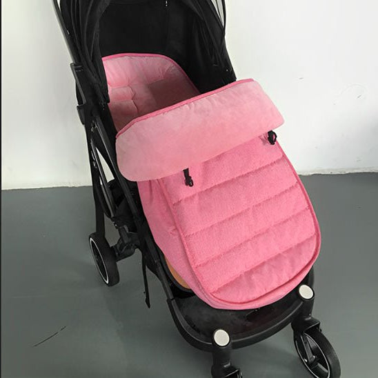 Une poussette noire avec une Chancelière pour Poussette rose en tissu Oxford imperméable pour la protection contre les intempéries, présentée à l'intérieur sur un sol gris et sur un fond de mur blanc.