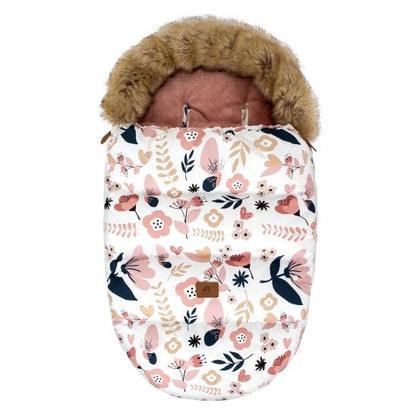 La Chancelière Poussette | Hiver 0-24 mois est une gigoteuse bébé à fleurs roses, beiges et noires avec capuche en fausse fourrure et fentes supérieures, offrant confort bébé et protection thermique, idéale pour les balades hivernales.