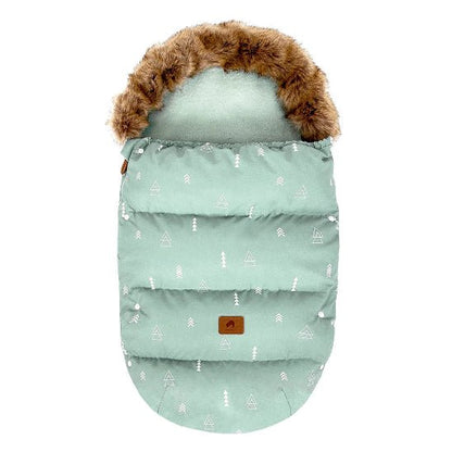 La Chancelière Poussette | Hiver 0-24 mois est une chancelière d'hiver vert menthe avec une capuche en fausse fourrure, des motifs géométriques d'arbres blancs et un empiècement en cuir marron. Douce et chaude, elle assure protection thermique et confort à votre bébé.