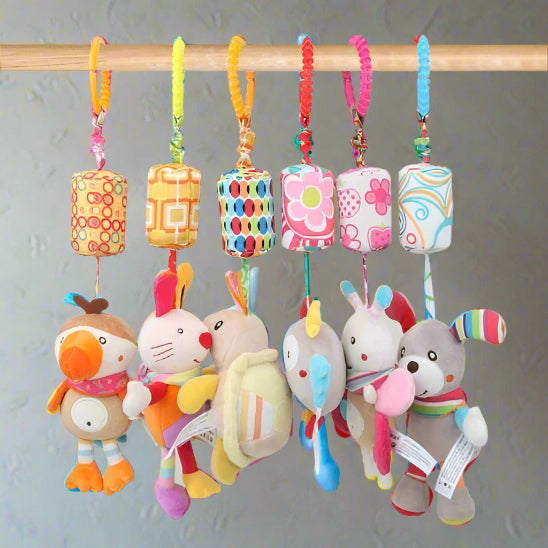 Cinq peluches colorées Jouet - Hochet Bébé sont suspendues à une tige en bois par des boucles de tissu à motifs. Elles présentent des couleurs vives, des formes et des motifs ludiques, parfaits pour stimuler l'éveil sensoriel de bébé sur un fond neutre.