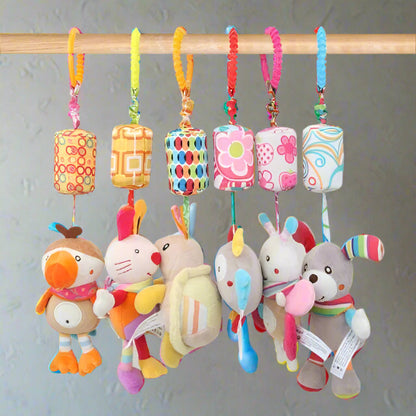 Cinq peluches colorées Jouet - Hochet Bébé sont suspendues à une tige en bois par des boucles de tissu à motifs. Elles présentent des couleurs vives, des formes et des motifs ludiques, parfaits pour stimuler l'éveil sensoriel de bébé sur un fond neutre.