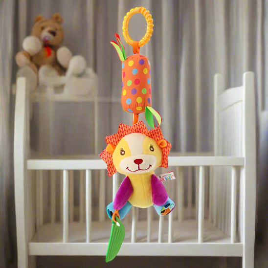 Un Jouet - Hochet Bébé vibrant avec une poignée à pois est suspendu devant un berceau blanc, tandis qu'un ours en peluche repose sur une table à langer à proximité, créant ainsi un espace accueillant pour l'éveil sensoriel.