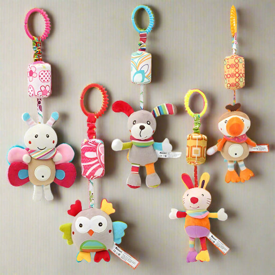 Six peluches colorées Jouet - Hochet Bébé en forme de papillon, de chien, d'oiseau, de hibou, de lapin et autres sont suspendues par des anneaux et des clips, idéales pour la découverte sensorielle. Présentés sur un fond uni.