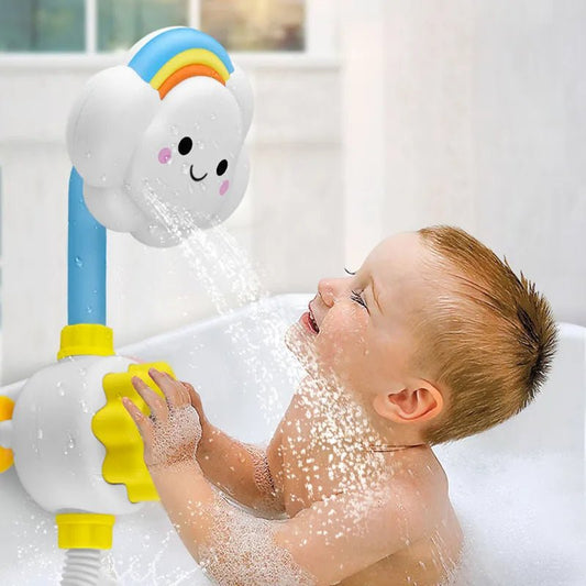Un jeune enfant est assis dans une baignoire bien éclairée, cherchant le Jouet de bain - jet d'eau - une pomme de douche en forme de nuage avec un arc-en-ciel - qui pulvérise de manière ludique de doux jets d'eau sur son visage et ses mains.