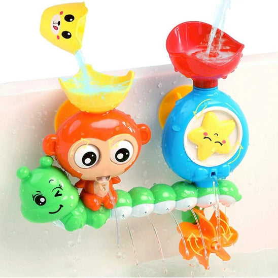 Deux jouets de bain en plastique coloré sont fixés à la paroi de la baignoire. Un singe orange et un appareil bleu avec une étoile jaune sont tous deux équipés de gobelets rotatifs pour un jeu amusant lorsque l'eau coule dessus.