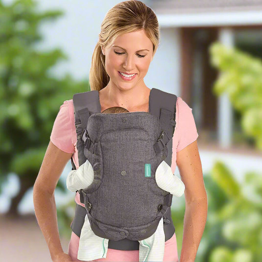 À l'extérieur, une femme porte un t-shirt rose et porte son bébé dans le porte-bébé FlipAdvanced™. La tête du bébé repose sous son menton, ses bras et ses jambes étant visibles depuis le porte-bébé.