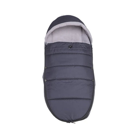 La Poussette Chancelière est une chancelière matelassée noire et grise avec un dessus à capuche pour une protection thermique, présentée sur un fond blanc.