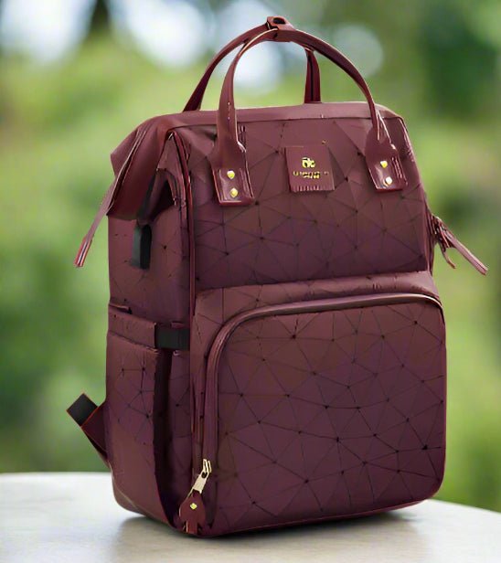 Le Sac a Langer dos | LifeEscape™ est un sac à dos marron avec un motif géométrique, des fermetures éclair dorées, des poches avant et latérales, et des poignées supérieures - parfait pour les parents modernes en déplacement.