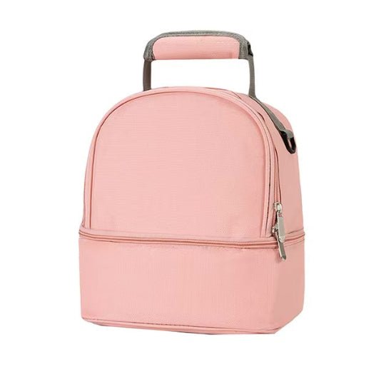 Le Sac Bebe - Petit est un sac à lunch isotherme rose clair avec une poignée supérieure et des compartiments doubles, assurant d'excellentes performances thermiques, présenté sur un fond blanc uni.