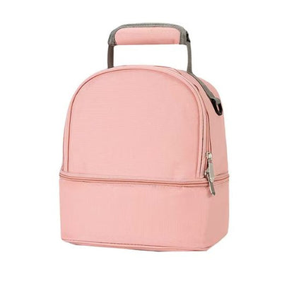 Le Sac Bebe - Petit est un sac à lunch isotherme rose clair avec une poignée supérieure et des compartiments doubles, assurant d'excellentes performances thermiques, présenté sur un fond blanc uni.