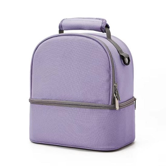 Le Sac Bebe - Petit en violet clair présente une conception à double compartiment avec une poignée supérieure, un compartiment principal et une section inférieure zippée séparée pour des performances thermiques optimales, présentées sur un fond blanc uni.