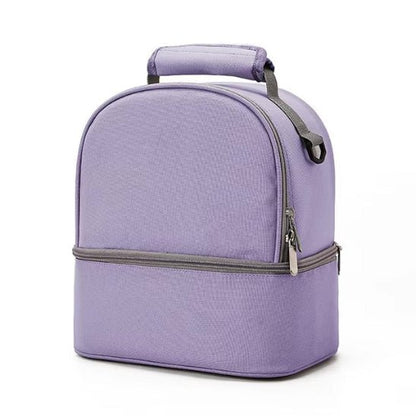 Le Sac Bebe - Petit en violet clair présente une conception à double compartiment avec une poignée supérieure, un compartiment principal et une section inférieure zippée séparée pour des performances thermiques optimales, présentées sur un fond blanc uni.