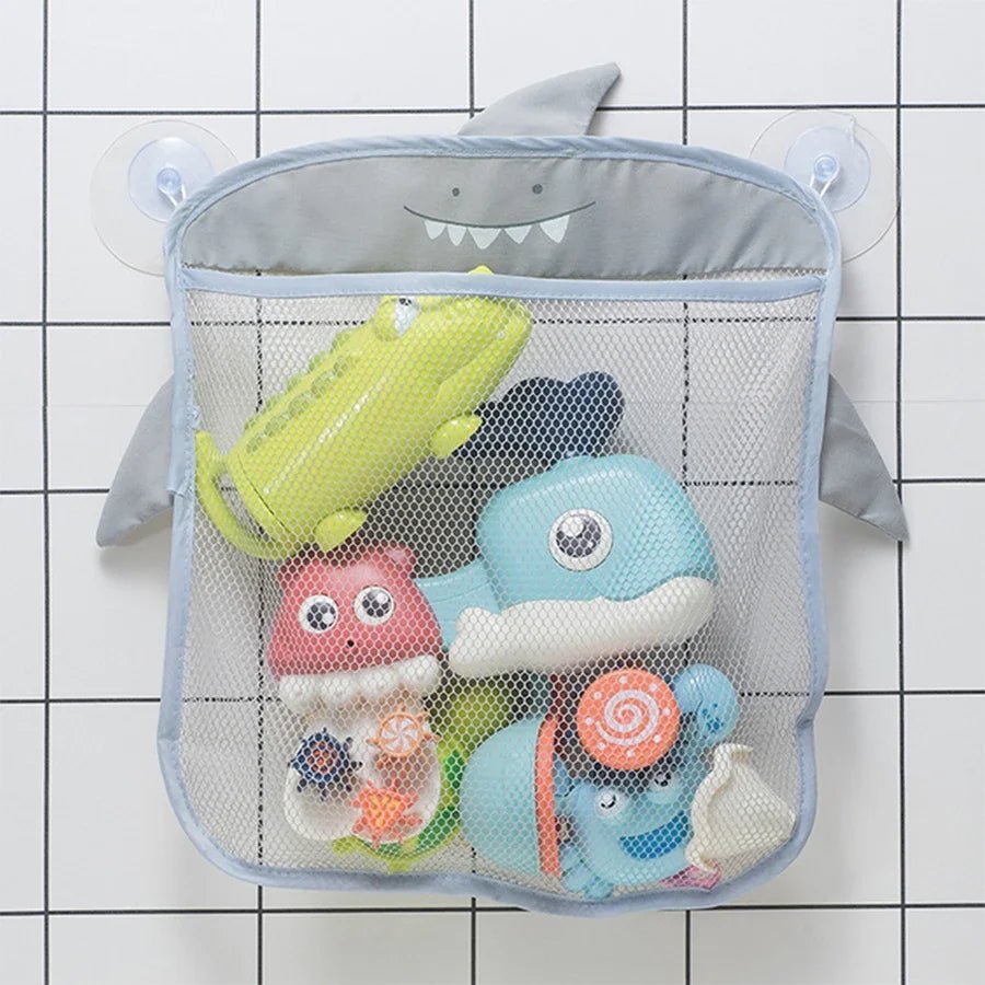 Le sac de rangement - jouet de bain avec ventouses maintient votre salle de bain organisée, en maintenant soigneusement les jouets de bain colorés - crocodile jaune, baleine bleue, pieuvre rouge, escargot et baleine bleu clair - contre le mur carrelé.