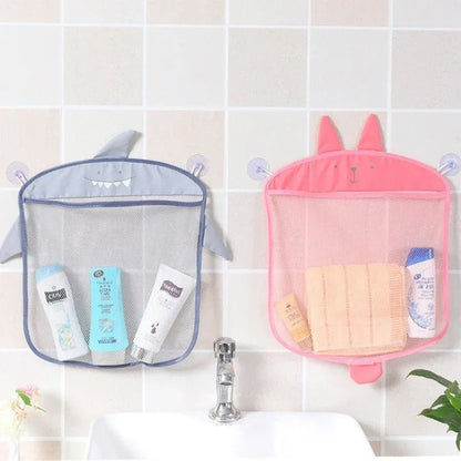 Deux sacs de rangement pour jouets de bain, en forme de requin et de lapin, sont fixés au-dessus du lavabo. Le requin accueille les jouets de bain ou les articles de toilette ; le lapin accueille les serviettes pliées pour une salle de bain bien organisée.