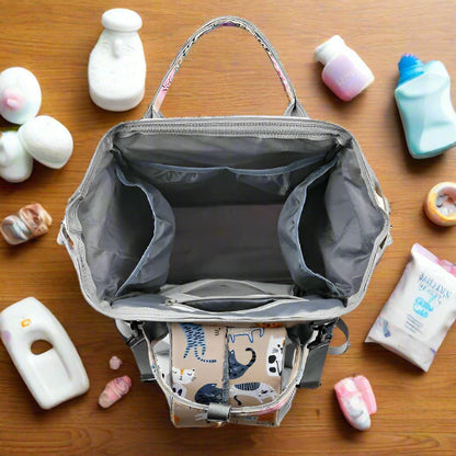 Voici le Sac pour Bebe | Chat : un sac à dos gris et beige à motif animalier. Il est doté d'une fermeture à glissière, de deux poignées, d'une bandoulière réglable et de compartiments spacieux avec plusieurs poches pour l'organisation, parfait comme sac polyvalent.